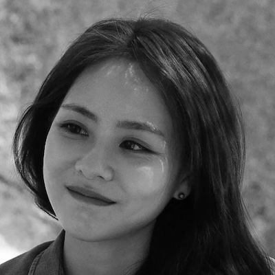 Image Description: black and white portrait of a pale woman with long, dark hair, smiling softly.