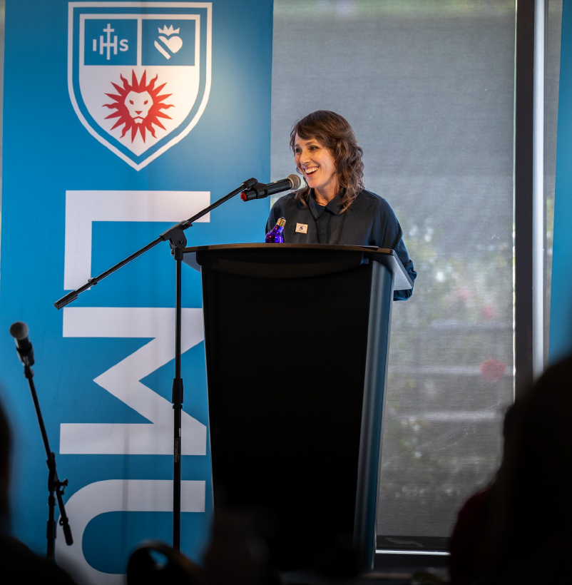 A photo of Amanda Christy standing at a podium.